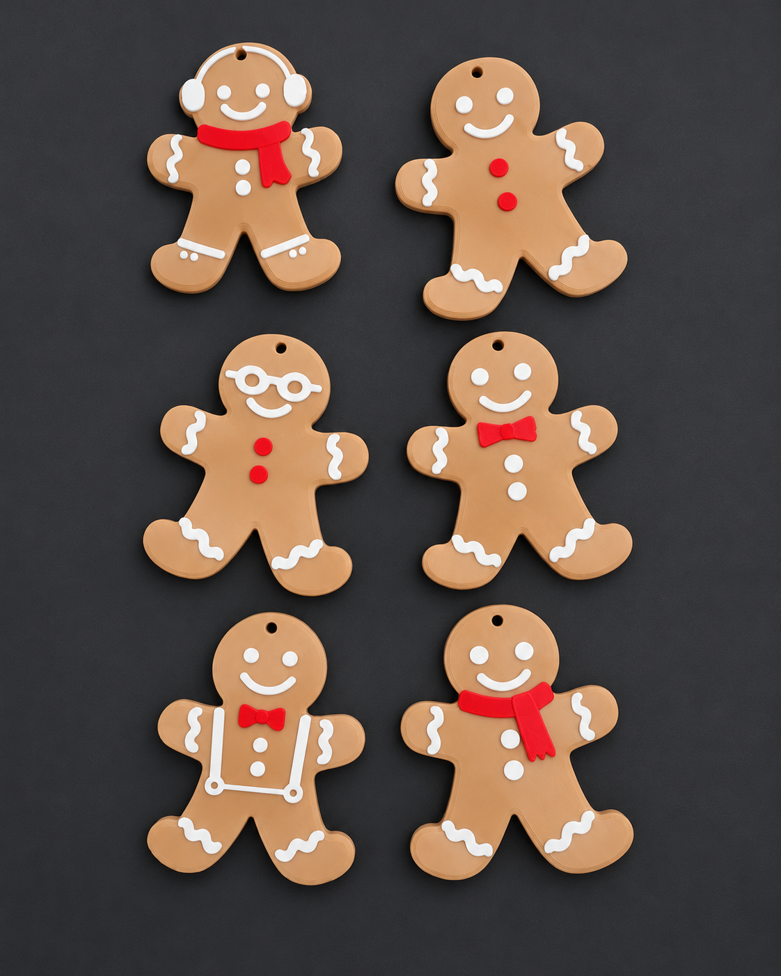 Seis enfeites de boneco de gengibre impressos em 3D, com detalhes brancos e vermelhos, sobre fundo grafite.
