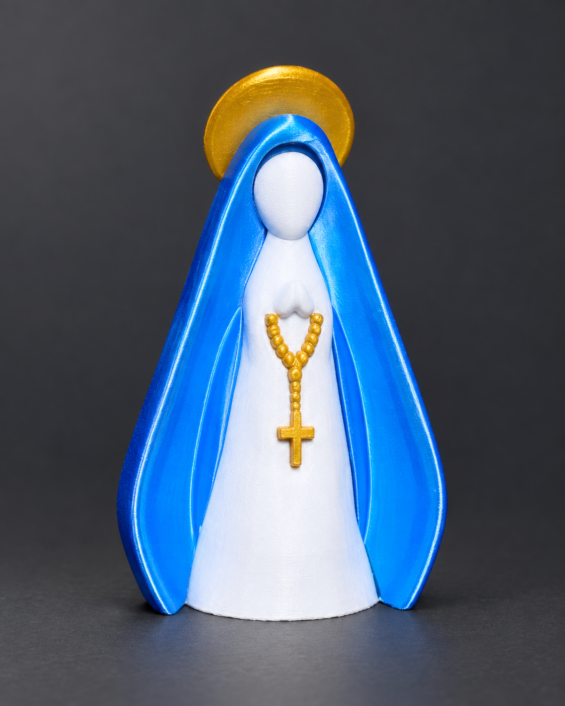 Imagem estilizada de Nossa Senhora impressa em 3D com manto azul brilhante, corpo branco, terço e auréola dourados.