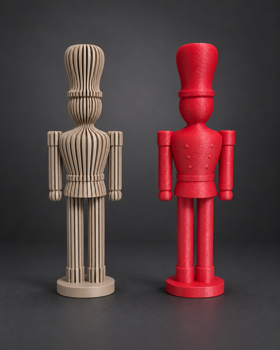 Dois soldadinhos quebra-nozes impressos em 3D, um bege canelado e um vermelho texturizado, sobre fundo grafite.